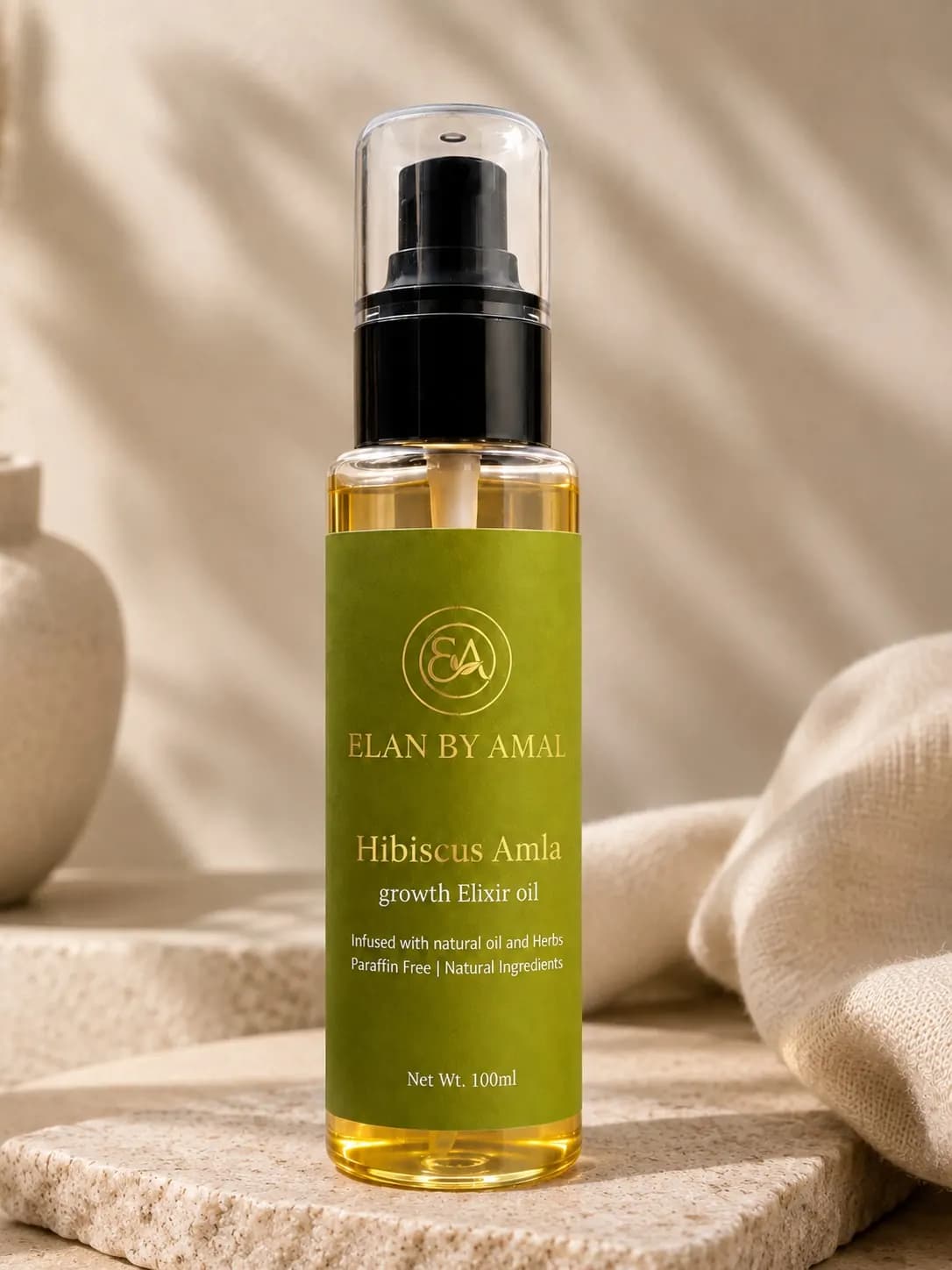 Hair oil bottle on travertine stone beside folded linen